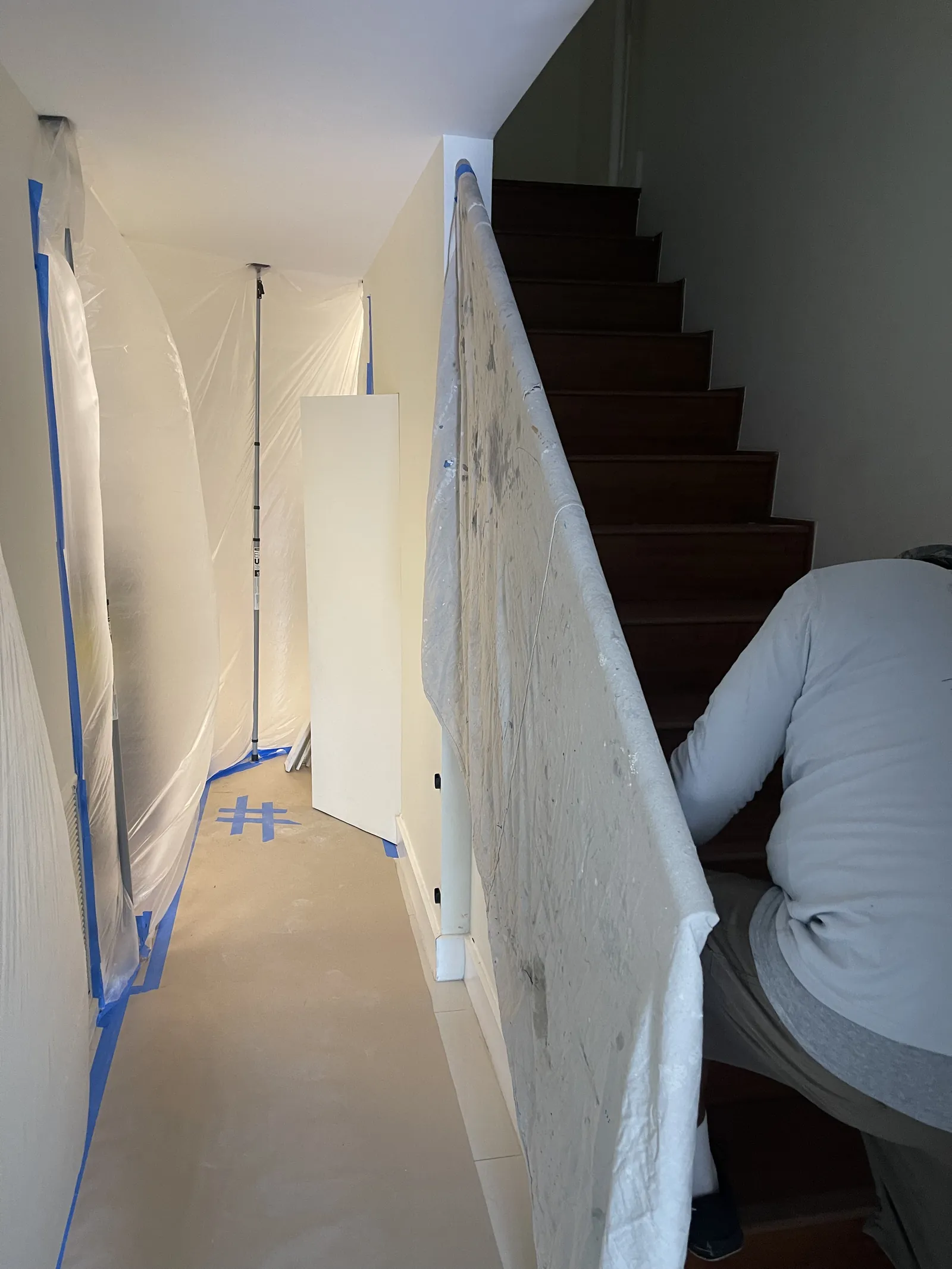 Plastic containment barriers, taped floor protection, and padded stair protection in a renovation area